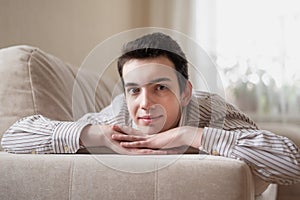 Teenager young man lying on sofa at home