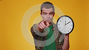 Teenager young man showing time on clock watch, ok, thumb up, approve, pointing finger at camera