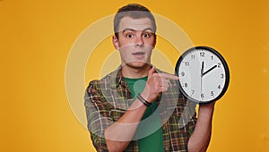 Teenager young man showing time on clock watch, ok, thumb up, approve, pointing finger at camera