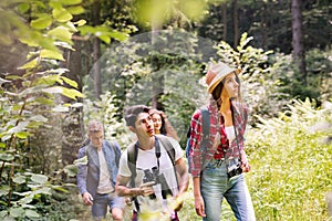 Teenagers with backpacks hiking in forest. Summer vacation.