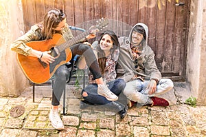 Teenagers best friends playing guitar outdoors