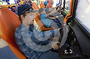 Teenagers boy plays on the gaming car simulator in the club