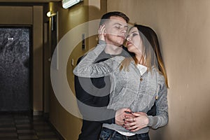 Teenagers boyfriend and girlfriend hugging each other in the corridor of an apartment building