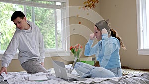 teenagers brother and sister study online at school sit in the same room together near laptop online conference look for