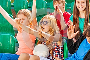 Teenagers cheer for team during game at stadium