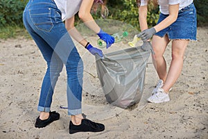 Teenagers cleaning plastic trash in nature, riverbank