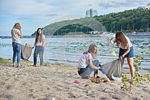 Teenagers cleaning plastic trash in nature, riverbank