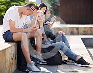 Teenagers communicate in schoolyard