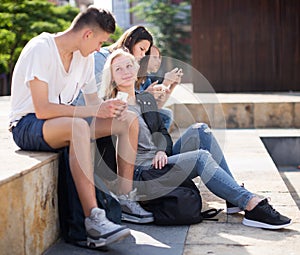 Teenagers communicate in schoolyard