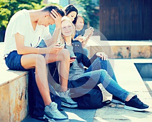 Teenagers communicate in schoolyard