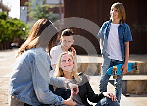 Teenagers communicate in schoolyard