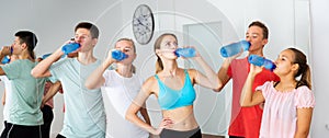 Teenagers drinking water during break in dance class