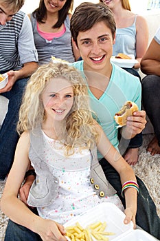 Teenagers eating burgers and fries