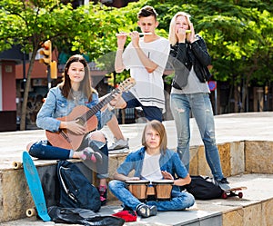 Teenagers friends playing musical instruments