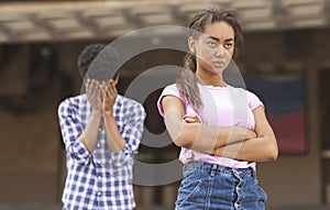 Teenagers having relationship difficulties. Girl sulking to her upset boyfriend