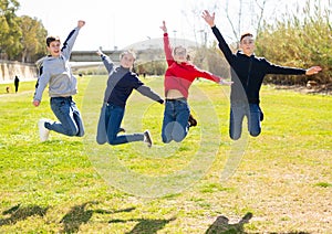 Teenagers jumping on green lawn