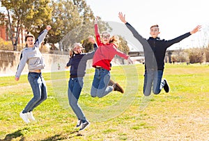 Teenagers jumping on green lawn