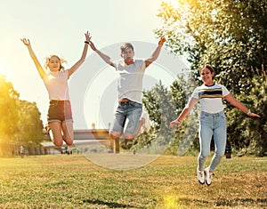 Teenagers jumping on green lawn in summertime