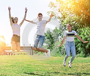 Teenagers jumping on green lawn in summertime