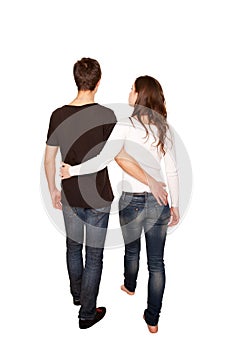 Teenagers in love, boy and girl hugging and walking. Rear view.