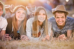 Teenagers lying on the ground in front of tents