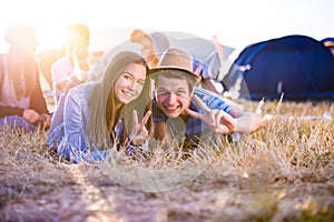 Teenagers lying on the ground in front of tents