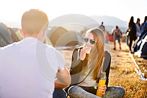 Teenagers on music festival resting, eating and drinking