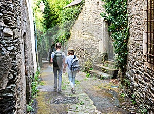 Teenagers people and travel concept. Teens walking in the street of an old town, historical centre of the town, Rochefort-en-Terre