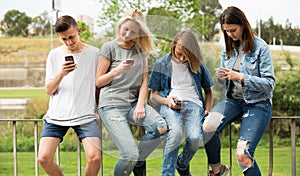 Teenagers with phones in park