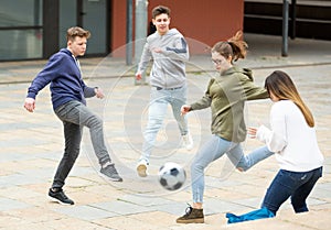 Teenagers play street football with excitement on street