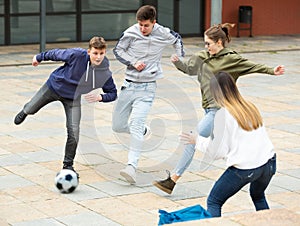 Teenagers play street football with excitement on street