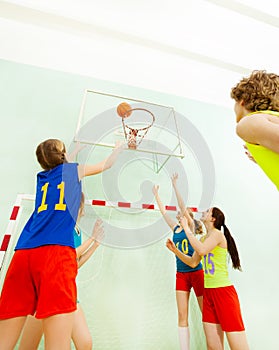 Teenagers playing basketball in sports hall