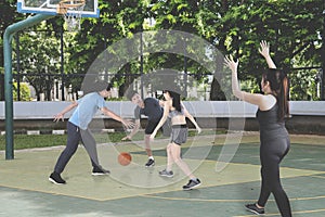 Teenagers playing basketball together at outdoors