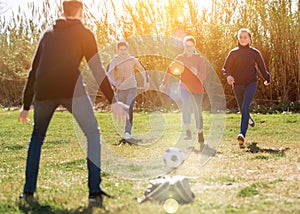 Teenagers playing football outdoors