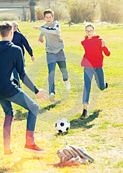 Teenagers playing football outdoors