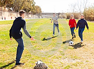 Teenagers playing football outdoors
