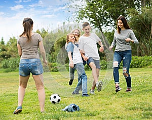 Teenagers playing football in park