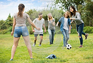 Teenagers playing football in park