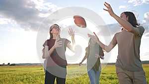 teenagers playing rugby in the park. a group of teenagers play american football run outdoors in the park in summer