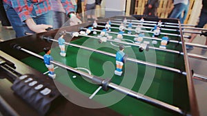 Teenagers playing table football. Young office people enjoying table soccer game