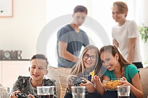 Teenagers playing video games at home