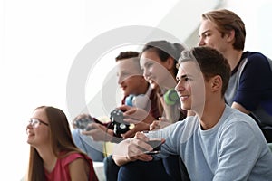 Teenagers playing video games at home