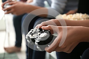 Teenagers playing video games at home, closeup