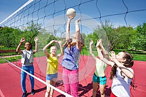 Teenagers are playing volleyball on the court