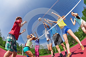 Teenagers playing volleyball on the game court