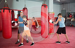 Teenagers posing in fighting stance at boxing gym