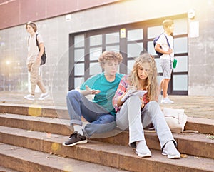 Teenagers preparing for exams on stairs in campus