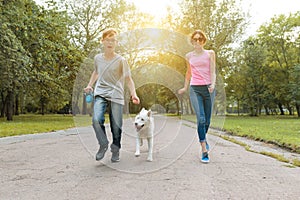 Teenagers running with a dog in the park