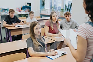 Teenagers sitting at school desks during math class lessons