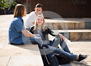 Teenagers socialize in the schoolyard on the street